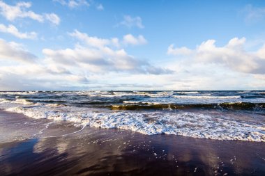Renkli kış günbatımı. Soğuk fırtınalı dalgalar ve bulutlar Baltık Denizi üzerinde, Letonya