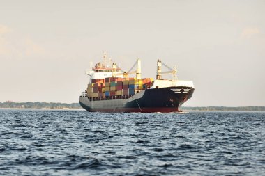 Güneşli bir günde Baltık Denizi 'nde vinçleri olan büyük bir kargo gemisi. Letonya