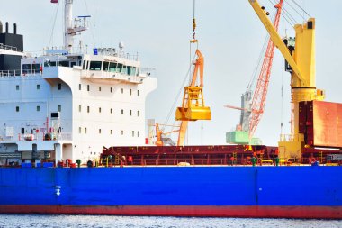 Büyük mavi kargo gemisi ve iskele vinçleri. Riga Körfezi, Baltık Denizi, Letonya