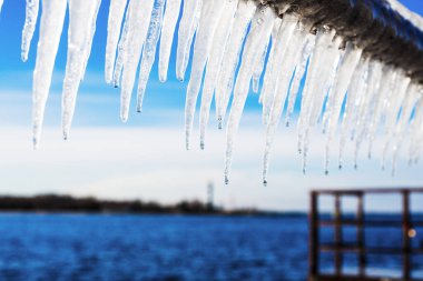 Güneşli bir günde, karla kaplı eski, paslı iskele. Buz parçaları yakın plan. Baltık Denizi, Letonya