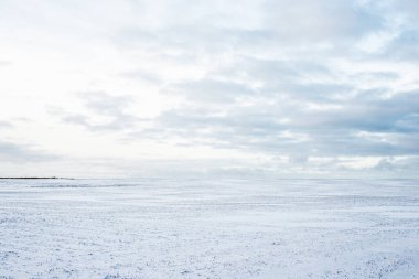 Gün batımında karla kaplı kırsal alanın panoramik manzarası. Akşam bulutları. Norveç