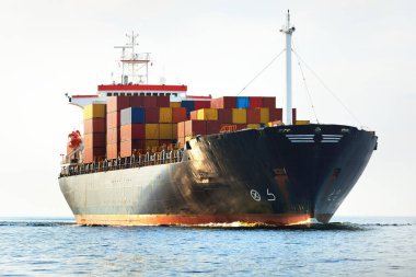 Norfolk limanından ayrılan büyük bir yük konteynırı gemisi, yakın plan. Bulutlu mavi gökyüzü. Virginia, ABD