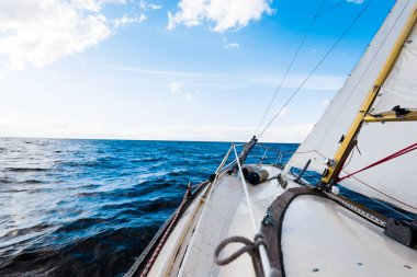 Açık bir günde yelkenli dolu bir yat. Güverteden pruvaya ve yelkenlere bir manzara. Dalgalar ve su sıçramaları. Baltık Denizi, Letonya