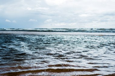 Fırtınalı hava. Bulutlu mavi gökyüzü ve dalgalar, Baltık denizi, Letonya