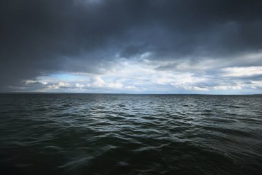 Baltık Denizi 'nin üzerindeki fırtınalı mavi gökyüzü. Dramatik parlayan bulutlar. Hanko Yarımadası, Finlandiya. Koyu deniz manzarası. Doğa, çevre, iklim değişikliği, hava durumu