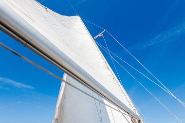 Açık bir Baltık Denizi 'nde güneşli bir günde beyaz yelkenli dolu bir yat. Güverteden pruvaya bir manzara. Estonya. Yelkenliyi yaklaştır.