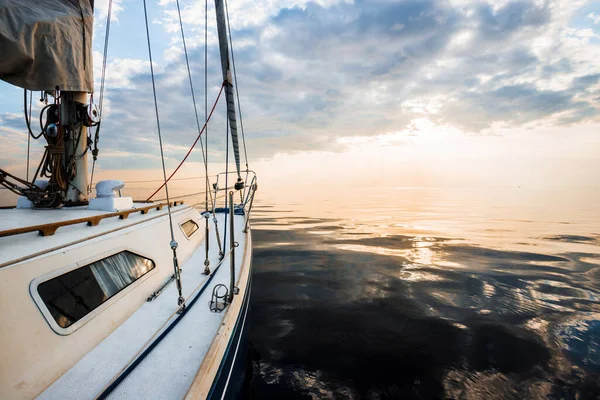 日落时 白色游艇在平静的水里航行 从甲板到船头的景色 桅杆和帆 让人目瞪口呆天然镜子 体育和娱乐主题 波罗的海 拉脱维亚 — 图库照片