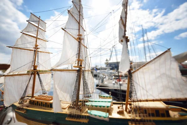 Scale model of a sailing ship close-up. Yachts in the background
