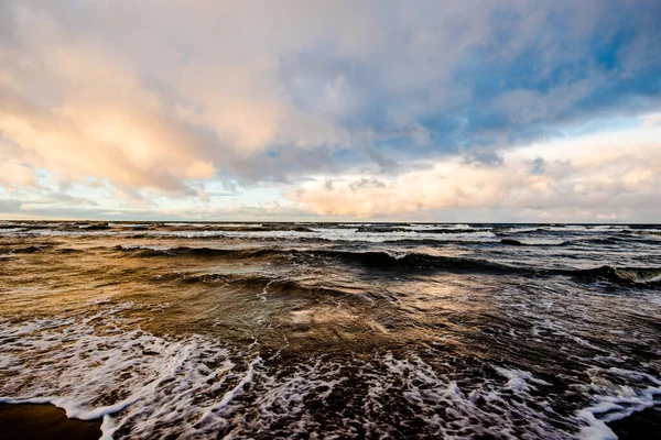 Renkli kış günbatımı. Soğuk fırtınalı dalgalar ve bulutlar Baltık Denizi üzerinde, Letonya
