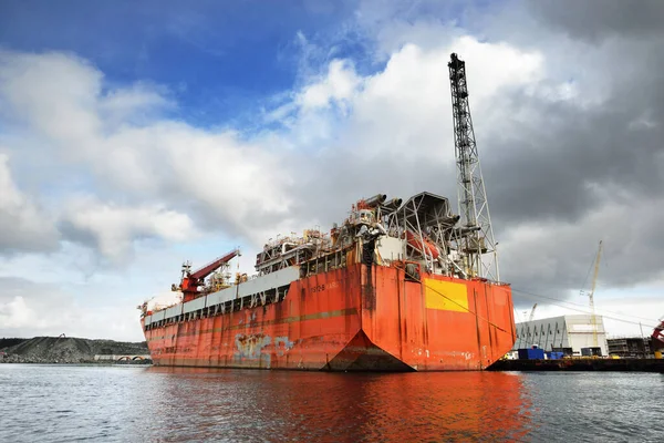 Floating, production, storage and offloading FPSO vessel moored to the shore in a port, close-up. Riga, Latvia. Fuel and power generation, industry, global communications, environmental damage