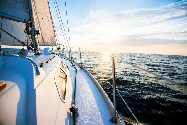 Sailing at sunset. A view from the yacht\'s deck to the bow and sails. Close-up. Baltic sea, Latvia