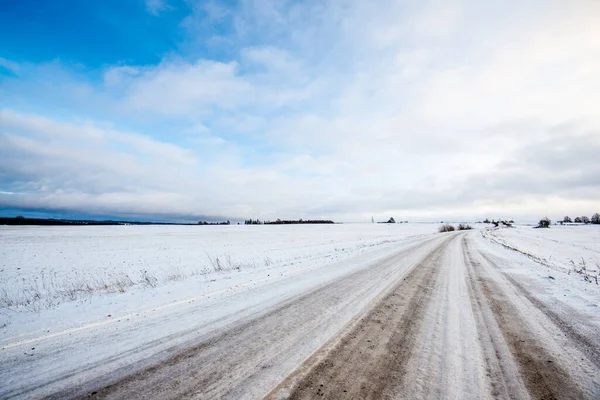 日没時に雪に覆われた田園地帯を通る道路 晴れた冬の日 — ストック写真