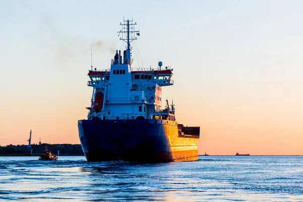 Groot Vrachtschip Een Loodsboot Bij Zonsondergang Close Vuurtoren Achtergrond Riga — Stockfoto