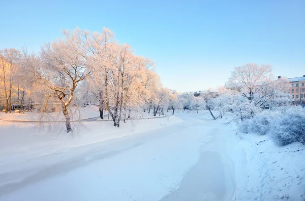 一个城市公园里阳光灿烂的冬日 冰封的里加运河 白雪覆盖的树木和房屋 拉脱维亚 — 图库照片