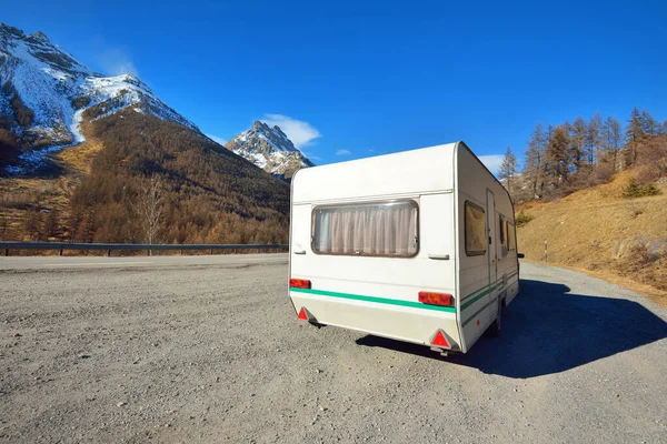 Caravan trailer stucked near the border of Italy because of travel ban, close-up. Coronavirus (COVID-19) outbreak, quarantine zone in France. An empty highway in a French Alps mountains on a clear day