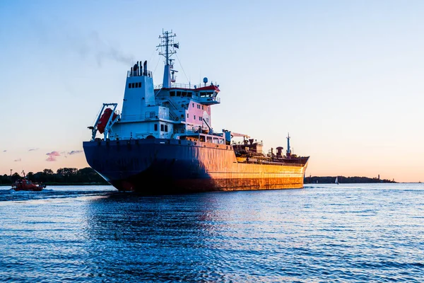 Nagy Teherhajó Egy Pilótahajó Naplementekor Közelkép Világítótorony Háttérben Riga Lettország — Stock Fotó