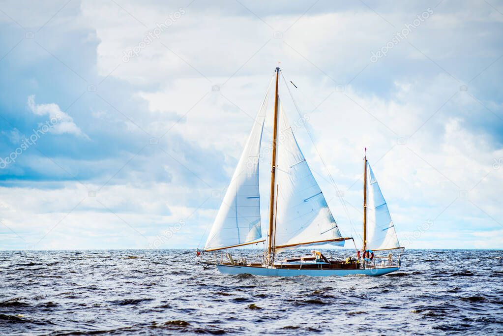 Old expensive vintage wooden sailboat (yawl) close-up, sailing in an open sea. Coast of Maine, US. Sport, cruise, recreation, leisure activity