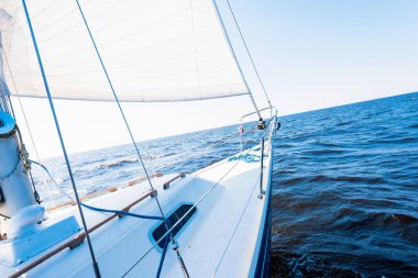 Açık bir Baltık Denizi 'nde, açık bir günde beyaz bir yat yüzüyor. Güverteden pruvaya ve yelkenlere bir manzara. Dalgalar ve su sıçramaları. Letonya