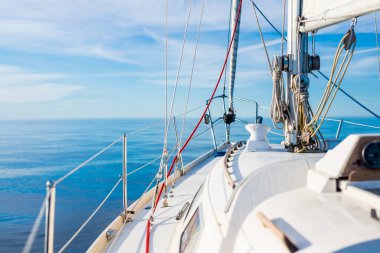 Güneşli bir günde Baltık Denizi 'nin durgun sularında yelken açan beyaz yelkenli bir yat. Güverteden pruvaya bir manzara. Estonya