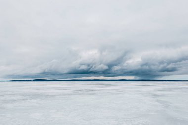 Kış manzarası. Donmuş karla kaplı göl manzarası. Arka planda orman var. Fırtınalı akşam bulutları. Onega Gölü, Karelia, Rusya