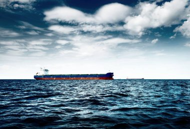 Bulutlu mavi gökyüzünün altında kargo gemisi, Baltık denizi, Letonya