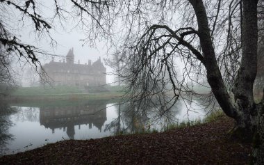 Kır manzarası. Şatonun manzarası ve küçük bir gölet. Arka planda orman var. Jaunmoku pils, Letonya