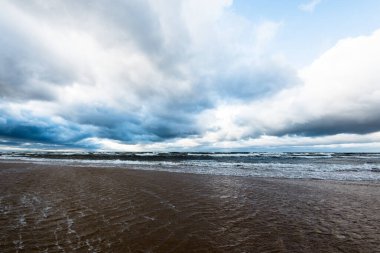 Sonbahar. Denizin üstünde fırtına bulutları. Dalgalar ve su sıçramaları. Sıcak akşam güneşi. Baltık Denizi, Garciems, Letonya