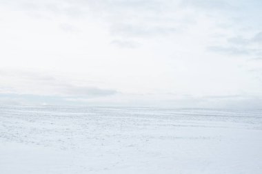 Gün batımında karla kaplı kırsal alanın panoramik manzarası. Akşam bulutları. Norveç