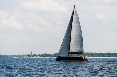 Açık bir günde yelkenli dolu bir yat geliyor. Direğin ve yelkenlerin yakın görüntüsü. Riga körfezi, Baltık denizi, atvia
