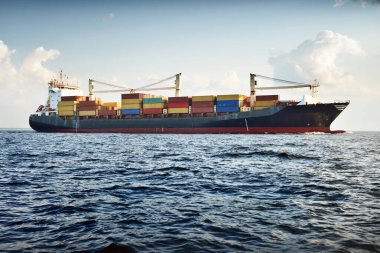 Güneşli bir günde Baltık Denizi 'nde vinçleri olan büyük bir kargo gemisi. Letonya