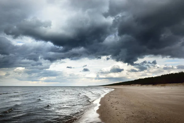 春のバルト海の砂浜の上に嵐の雲 劇的な空 波と水のスプラッシュ 暗い海の風景 ラトビア 気候変動 生態系 — ストック写真