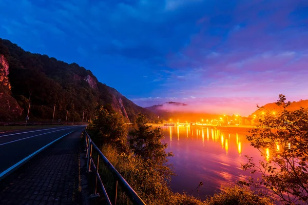 stock image A view of a small town Dinant, Belgium, at night. En empty road through the park