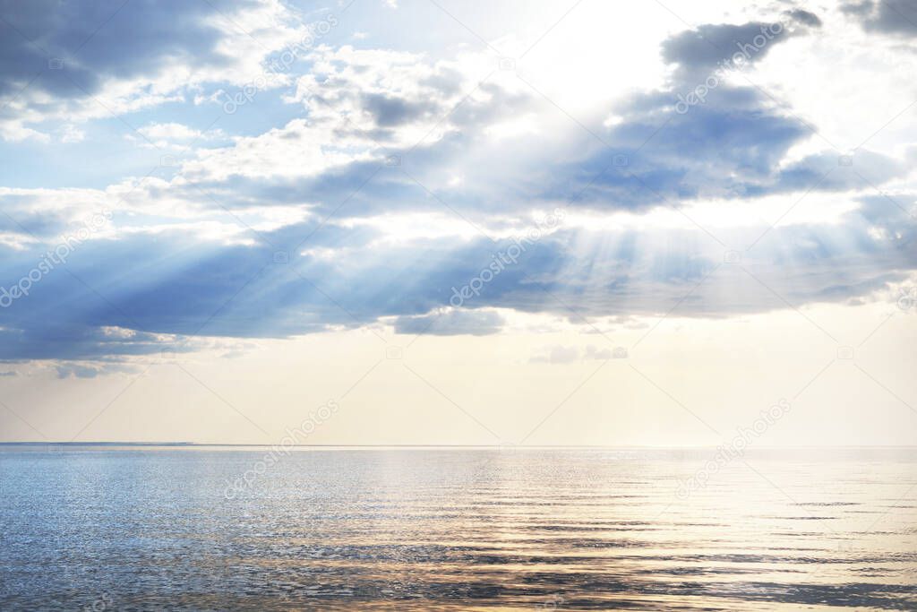 Spring seascape. The calm water. Beautiful colorful sunset over the Baltic Sea. White clouds. Latvia