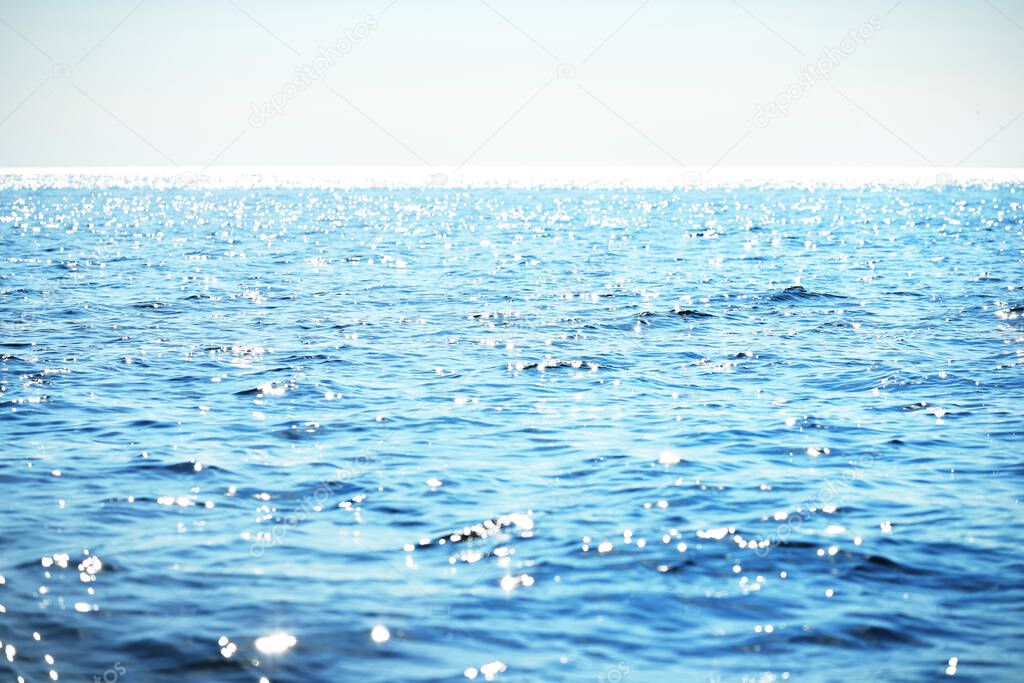 The calm water. A view of the Baltic sea on a sunny summer day. Blue water against the clear sky. Beautiful morning light