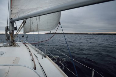 Yağmurdan sonra karanlık, dramatik gökyüzünün altında yalnız bir deniz feneri. Norveç, Kuzey Denizi 'nde yelken açan yattan bir manzara. Destansı bulut manzarası. Umut ve barışın sembolü. Spor, eğlence teması