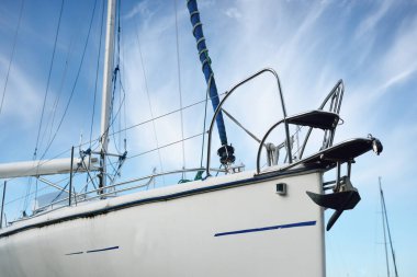 Modern yelkenli (kiralık) açık bir yaz gününde bir yat marinasında karada duruyor, yakın plan. Riga, Letonya. Tatiller, spor, amatör eğlence yelkenciliği, gezi, boş zaman aktiviteleri.