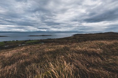 Jura adasının kıyıları, dağları ve vadilerinin panoramik hava manzarası. Bulutlu mavi gökyüzü. Fırtınalı hava. Paps of Jura, Inner Hebrides, İskoçya, İngiltere. Seyahat yerleri, turizm, ulusal simgeler