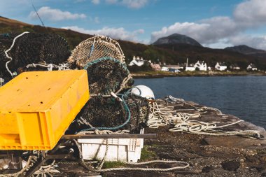 Balıkçı ağı ve ipler yakın plan. Açık mavi gökyüzünün altındaki dağ tepeleri (Paps of Jura) yakınlarındaki vadinin panoramik manzarası. Craighouse, Inner Hebrides, İskoçya, İngiltere. Geleneksel zanaat, gıda endüstrisi
