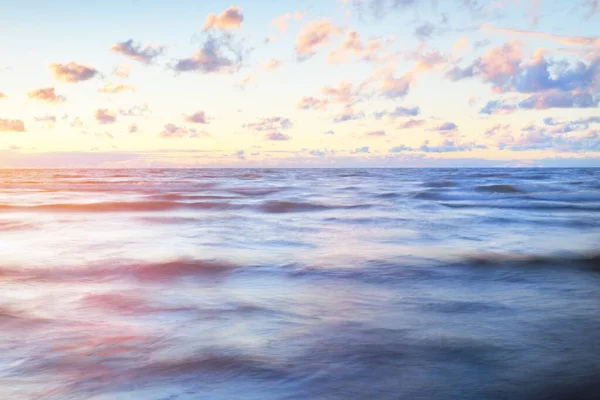 雷雨の後 海の上に壮大なカラフルな輝くピンクの夕日の雲 劇的な空だ 波と水が食感を飛ばす 牧歌的な海の景色 コンセプトイメージ 長時間露光 絵になる風景 — ストック写真