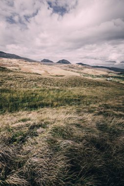 Karanlık fırtına gökyüzünün altındaki Paps of Jura 'nın (Beinn an ir) en yüksek dağı yakınındaki vadinin panoramik manzarası. Dramatik bulutlar. Jura Adası, Inner Hebrides, İskoçya, İngiltere. Atmosferik manzara.