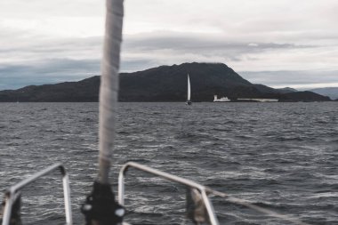 Yat manzaralı Jura adasının batı kıyısındaki kayalık kıyılara (uçurumlara) yelken açmak. Fırtınadan sonra dramatik bulutlar. Inner Hebrides, İskoçya, İngiltere. Atmosferik manzara