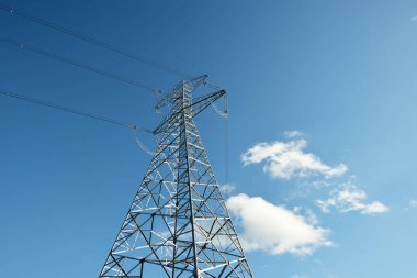 Elektrik hattı açık mavi gökyüzüne karşı, yakın plan. Şehir manzarası kavramı. Enerji, enerji üretimi, özel ekipman, endüstri, çevresel hasar, ekoloji, altyapı, ormanların tahrip
