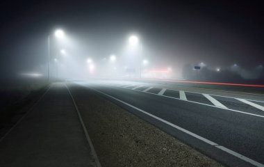 Gece sisli ve aydınlık yeni otoyolun panoramik manzarası. Ay ışığı. Karanlık şehir manzarası. Avrupa. Ulaşım, lojistik, seyahat, turizm, yolculuk, özgürlük, sürüş. Hareket bulanıklığı etkisi