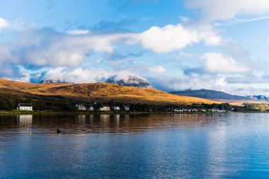 Jura Papaları 'nın yakınlarındaki vadiyi renkli fırtınalı günbatımı altında panoramik açıdan görmek. Geleneksel kır evleri. Dramatik bulut manzarası. Craighouse, Jura Adası, Inner Hebrides, İskoçya, İngiltere