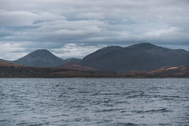 Yat manzaralı Jura adasının batı kıyısındaki kayalık kıyılara (uçurumlara) yelken açmak. Fırtınadan sonra dramatik bulutlar. Inner Hebrides, İskoçya, İngiltere. Atmosferik manzara