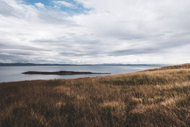 Jura adasının kıyıları, dağları ve vadilerinin panoramik hava manzarası. Bulutlu mavi gökyüzü. Fırtınalı hava. Paps of Jura, Inner Hebrides, İskoçya, İngiltere. Seyahat yerleri, turizm, ulusal simgeler