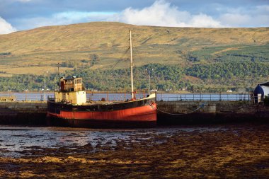 Loch Fyne yakınlarındaki sahil, orman ve tepelerin manzarası. Kırmızı balıkçı teknesi. Inveraray, Inner Hebrides, Argyll ve Bute, İskoçya, İngiltere