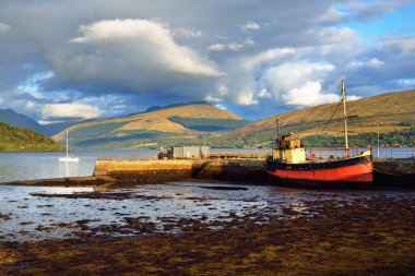 Loch Fyne yakınlarındaki sahil, orman ve tepelerin manzarası. Kırmızı balıkçı teknesi. Inveraray, Inner Hebrides, Argyll ve Bute, İskoçya, İngiltere