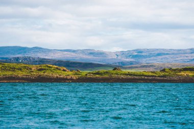 Yat manzaralı Jura adasının batı kıyısındaki kayalık kıyılara (uçurumlara) yelken açmak. Parlak bulutlu dramatik günbatımı gökyüzü. Inner Hebrides, İskoçya, İngiltere. Seyahat yerleri, işaretler
