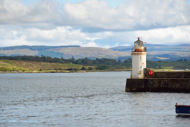 Küçük bir Ardrishaig köyünün kayalık kıyıları ve ormanlarının panoramik manzarası. Gezinti güvertesi ve deniz fenerine yakın çekim. Loch Fyne, Crinan Kanalı, Argyll ve Bute, İskoçya, İngiltere